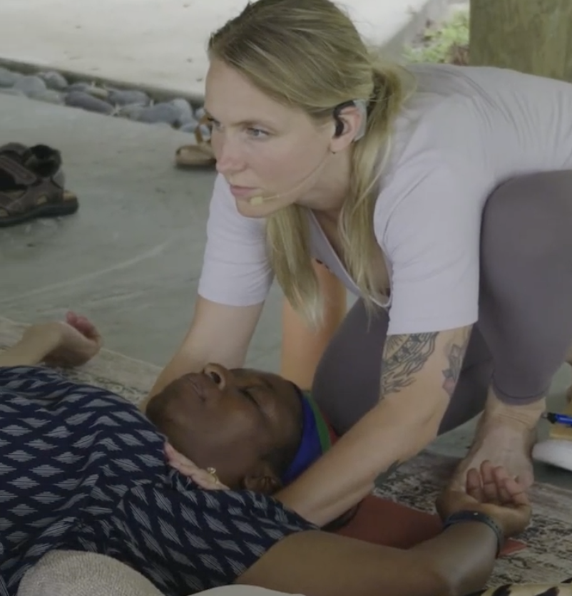 A Shepherd U facilitator gently guiding a resting participant through yoga nidra